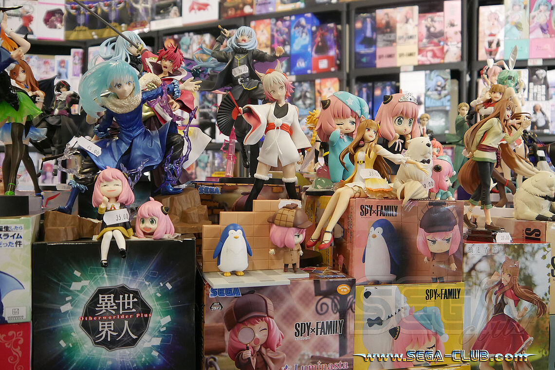 Mehrere Figuren aus Spy x Family und SEGA-Logos auf dem Verpackungen
