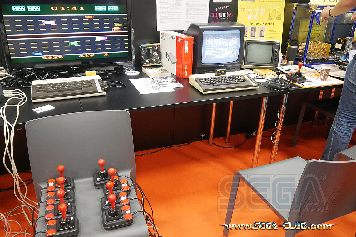 Retro Sticks gesammelt auf einem Stuhl, im Hintergrund Home Computer