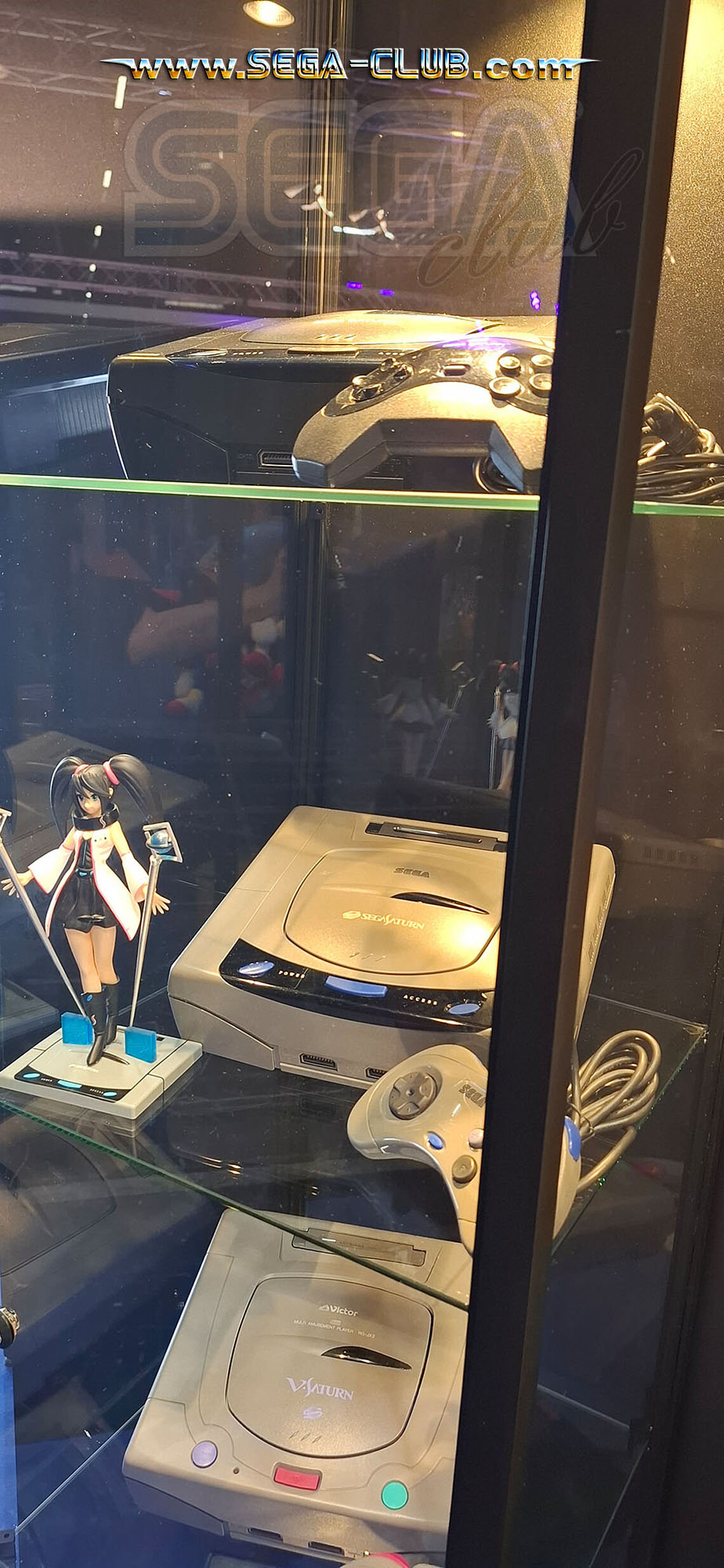 Vitrine mit Saturn Geräten und einer Figur mit Saturn-Design