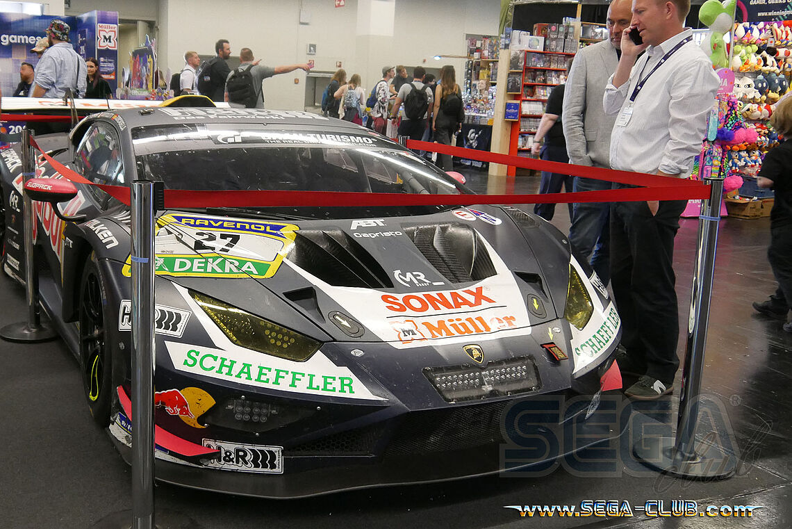 Ein schwarzer Lamborghini mit Werbeaufdruck zwischen Merchandise